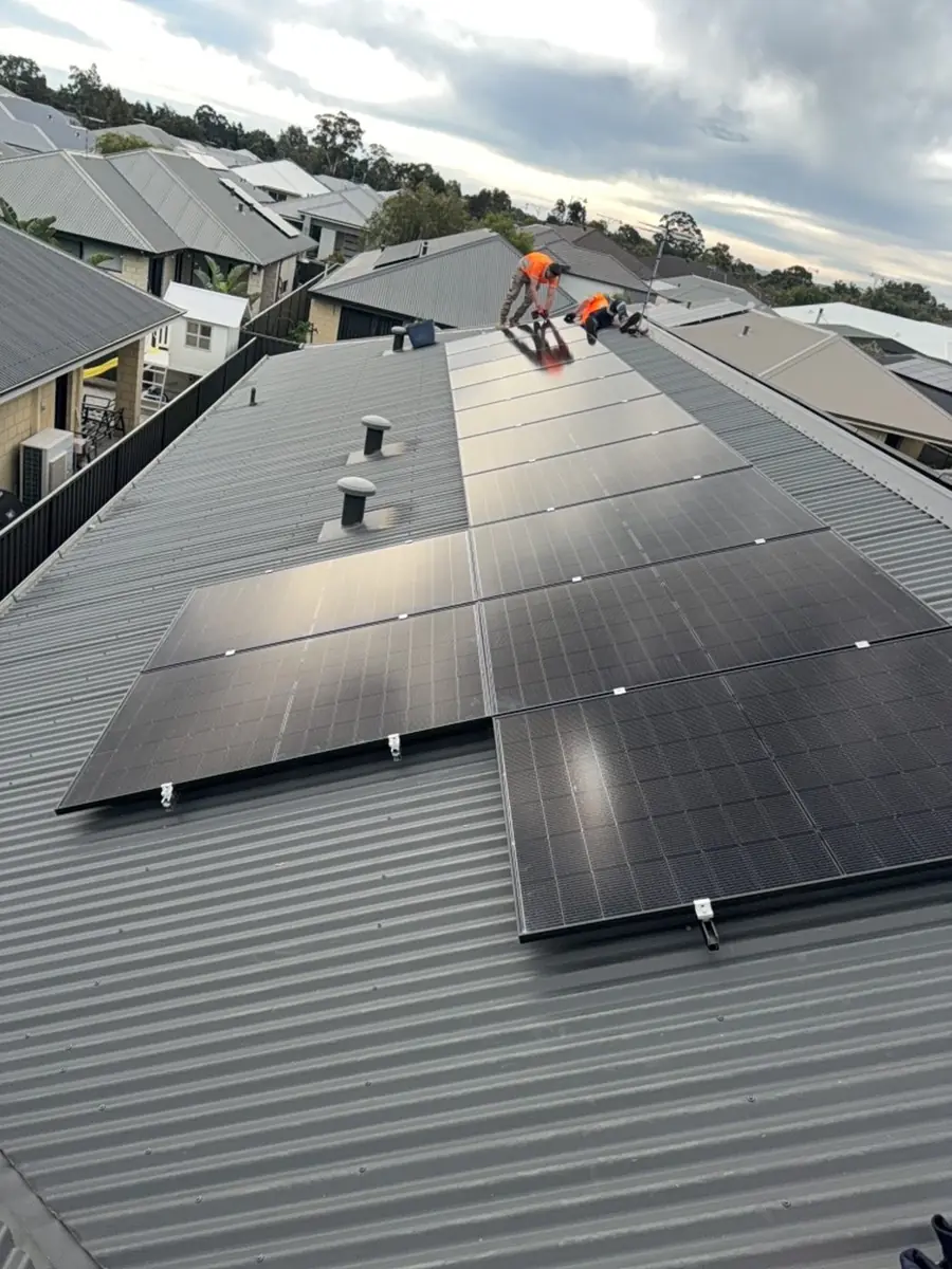 Two PPS installers fitting panels on a new-build roof