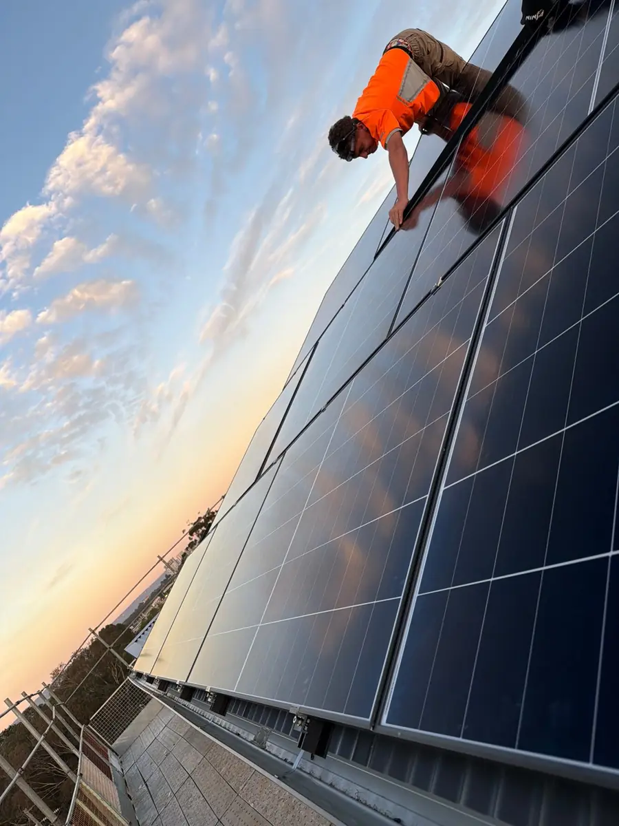 PPS electrician fitting solar panels on a Perth roof at sunset